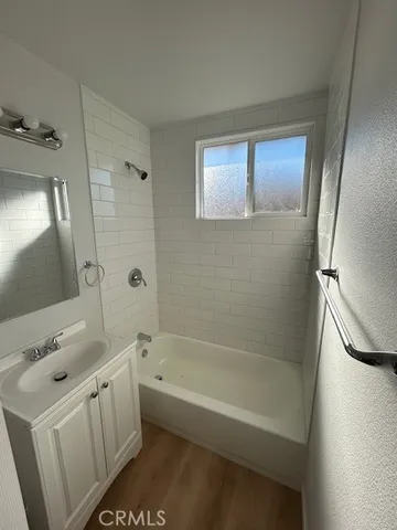 a bathroom with a tub a sink and a mirror