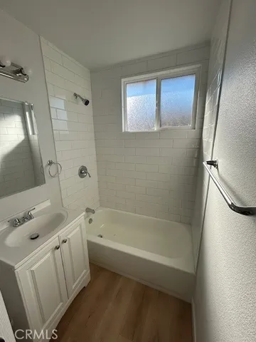 a bathroom with a tub a sink and a mirror