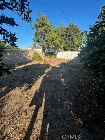 a view of a yard with wooden fence