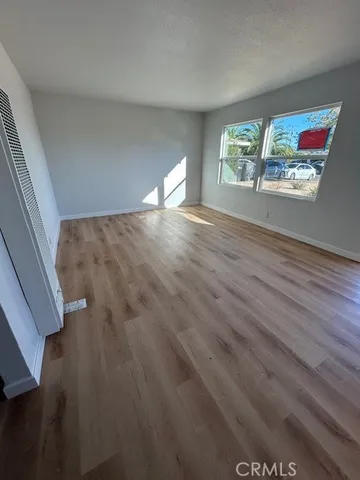 a view of empty room with window and wooden floor