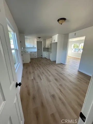 a view of empty room with wooden floor and window