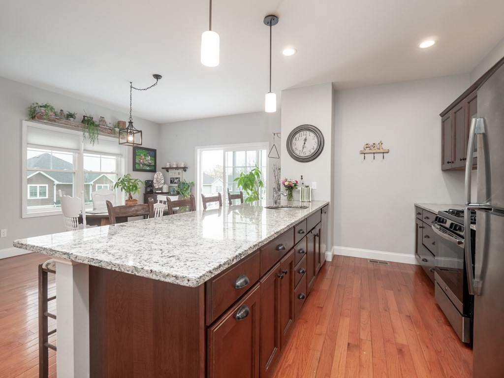 66 Oak Street, Unit 66 Clinton, MA 01510 - Photo 11 of 26 a kitchen with granite countertop a sink a counter top space a refrigerator and wooden floor