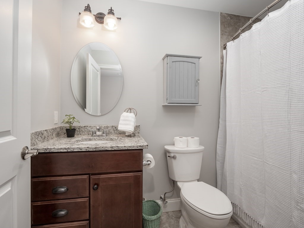 66 Oak Street, Unit 66 Clinton, MA 01510 - Photo 15 of 26 a bathroom with a granite countertop toilet sink and mirror