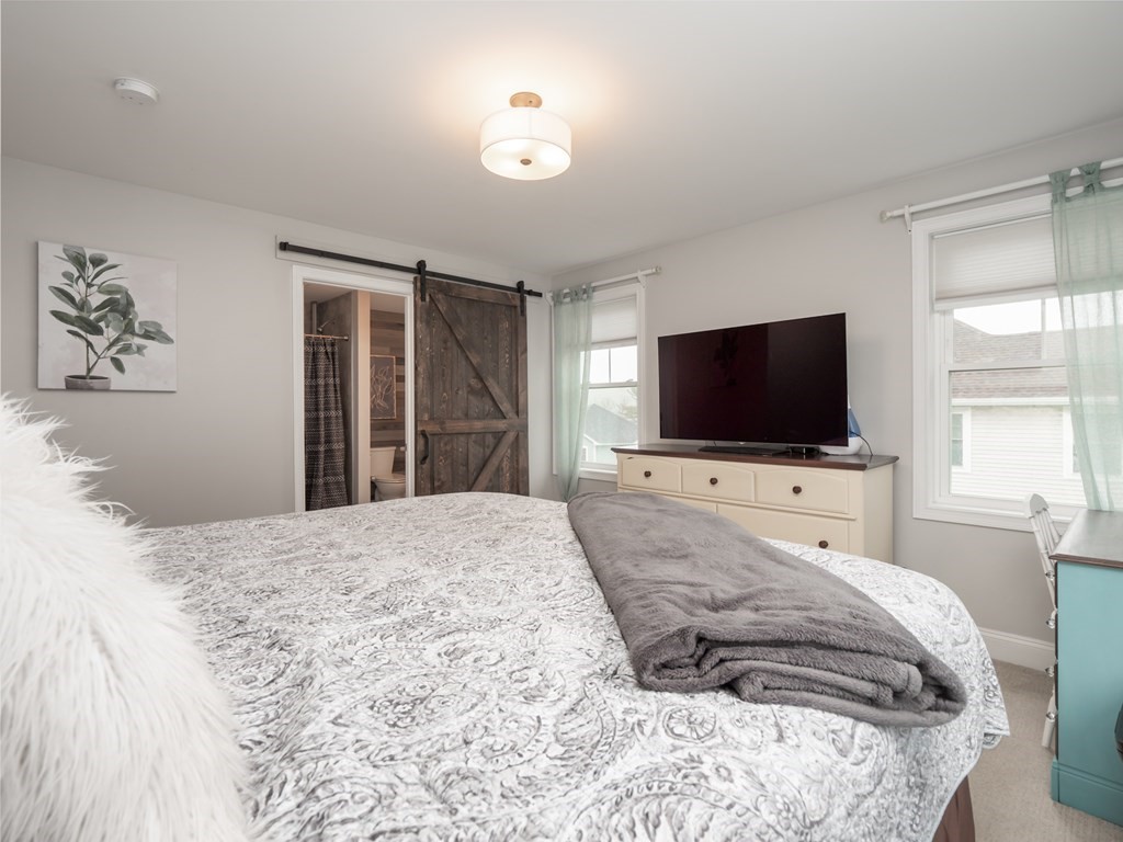 66 Oak Street, Unit 66 Clinton, MA 01510 - Photo 17 of 26 a bedroom with a bed and a flat screen tv