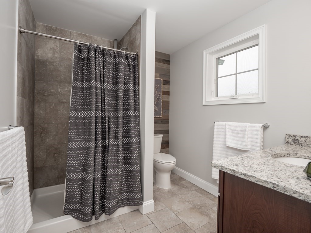 66 Oak Street, Unit 66 Clinton, MA 01510 - Photo 20 of 26 a bathroom with a granite countertop sink a toilet and shower