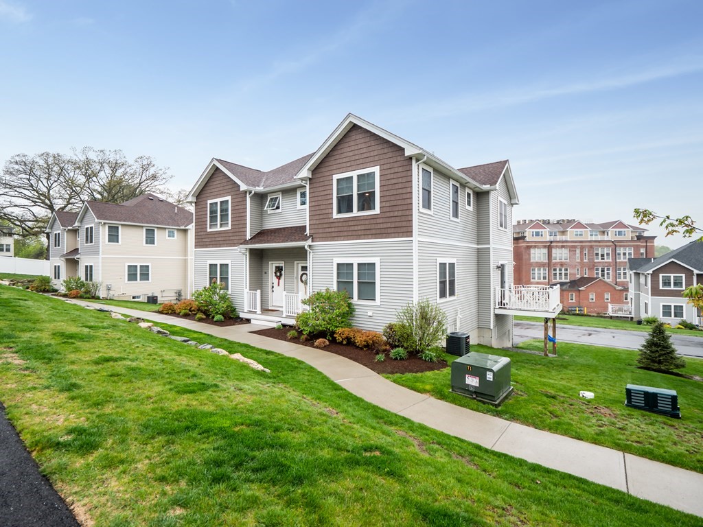 66 Oak Street, Unit 66 Clinton, MA 01510 - Photo 2 of 26 a front view of a house with a yard and garage