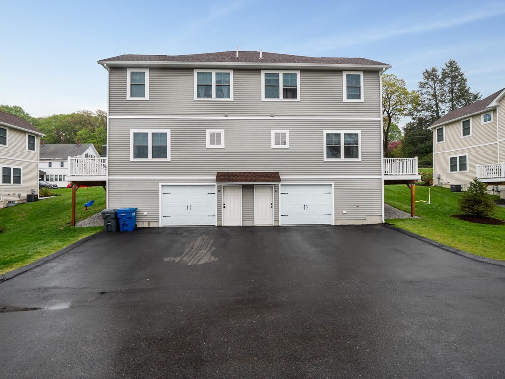 66 Oak Street, Unit 66 Clinton, MA 01510 - Photo 23 of 26 a view of a house with a yard and garage