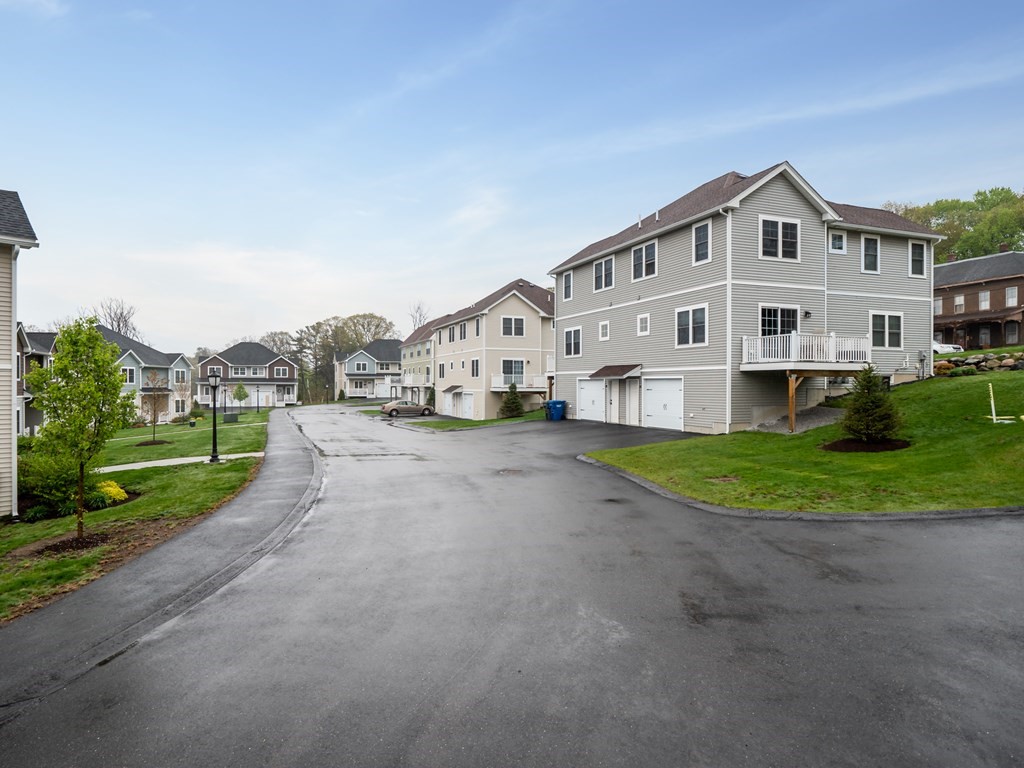 66 Oak Street, Unit 66 Clinton, MA 01510 - Photo 24 of 26 a view of a house with a big yard and large trees