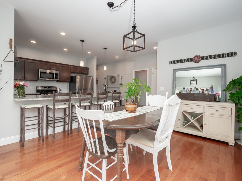 66 Oak Street, Unit 66 Clinton, MA 01510 - Photo 8 of 26 a kitchen with stainless steel appliances kitchen island granite countertop a wooden floor and white cabinets