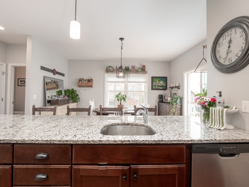 66 Oak Street, Unit 66 Clinton, MA 01510 - Photo 9 of 26 a kitchen with kitchen island granite countertop a sink a counter space and a dining table view