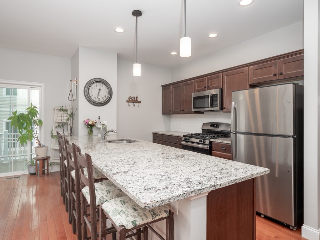 66 Oak Street, Unit 66 Clinton, MA 01510 - Photo 10 of 26 a kitchen with a table chairs refrigerator and microwave