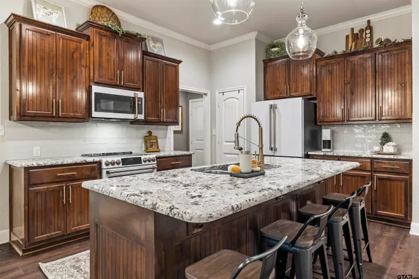 a kitchen with granite countertop wooden cabinets a stove top oven a sink and dishwasher