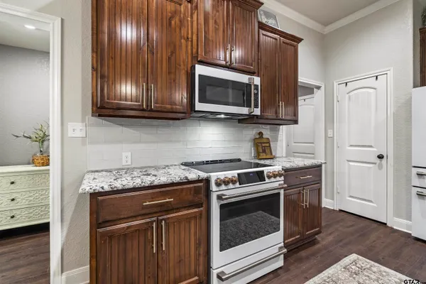 a kitchen with stainless steel appliances granite countertop wooden cabinets stove top oven and sink