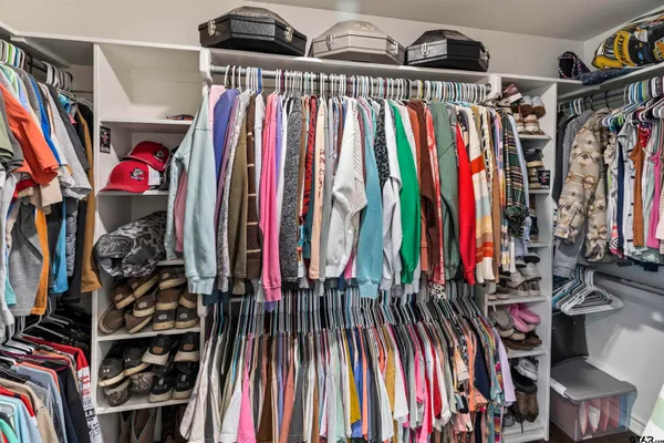 a view of walk in closet with clothes