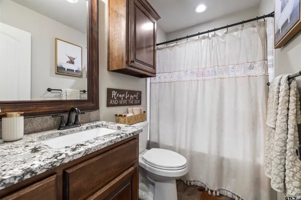 a bathroom with a granite countertop sink toilet and shower