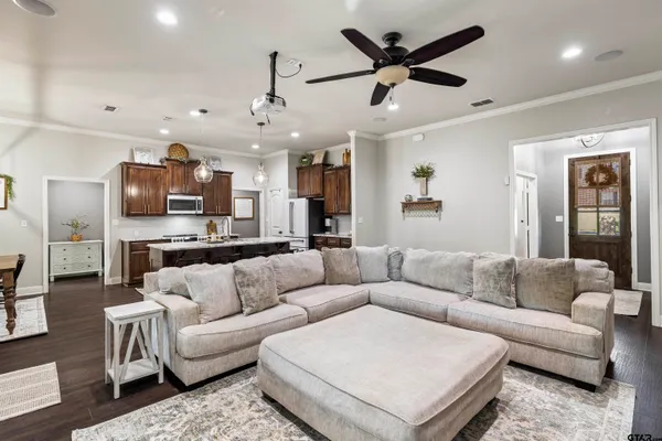 a living room with furniture kitchen view and a chandelier