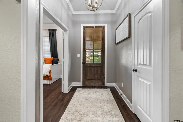 a view of a hallway with wooden floor and windows