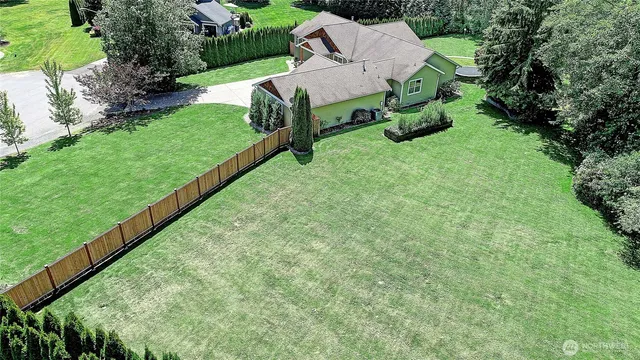 an aerial view of residential houses with outdoor space and trees