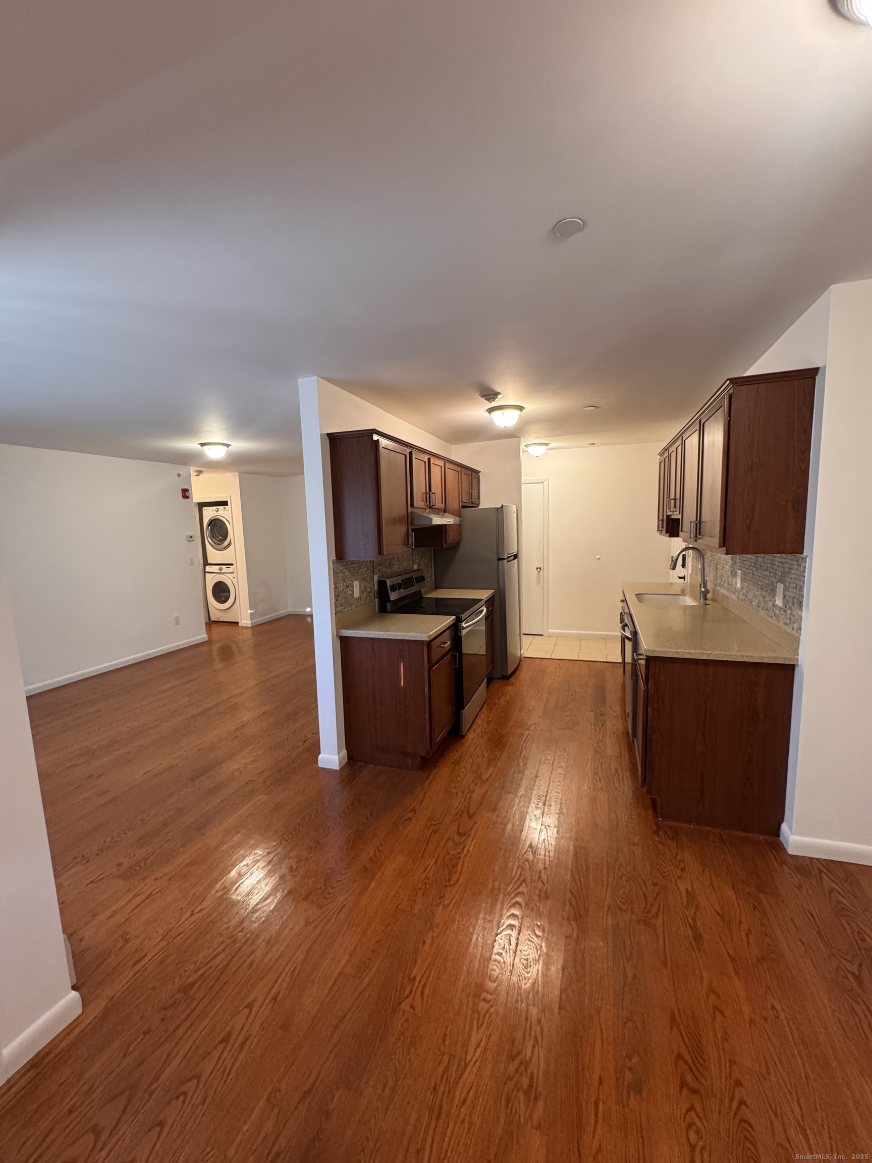 a kitchen with stainless steel appliances wooden floors and refrigerator
