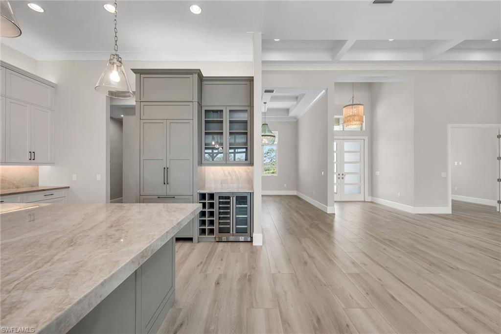 8871 Nevis Way Naples, FL 34112 - Photo 11 of 50 a kitchen with granite countertop a stove and a wooden floors