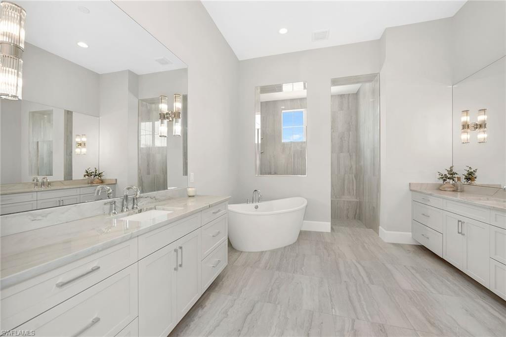 8871 Nevis Way Naples, FL 34112 - Photo 15 of 50 a spacious bathroom with a double vanity sink a toilet and a tub