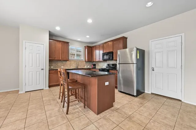 a kitchen with stainless steel appliances granite countertop a refrigerator stove top oven and sink