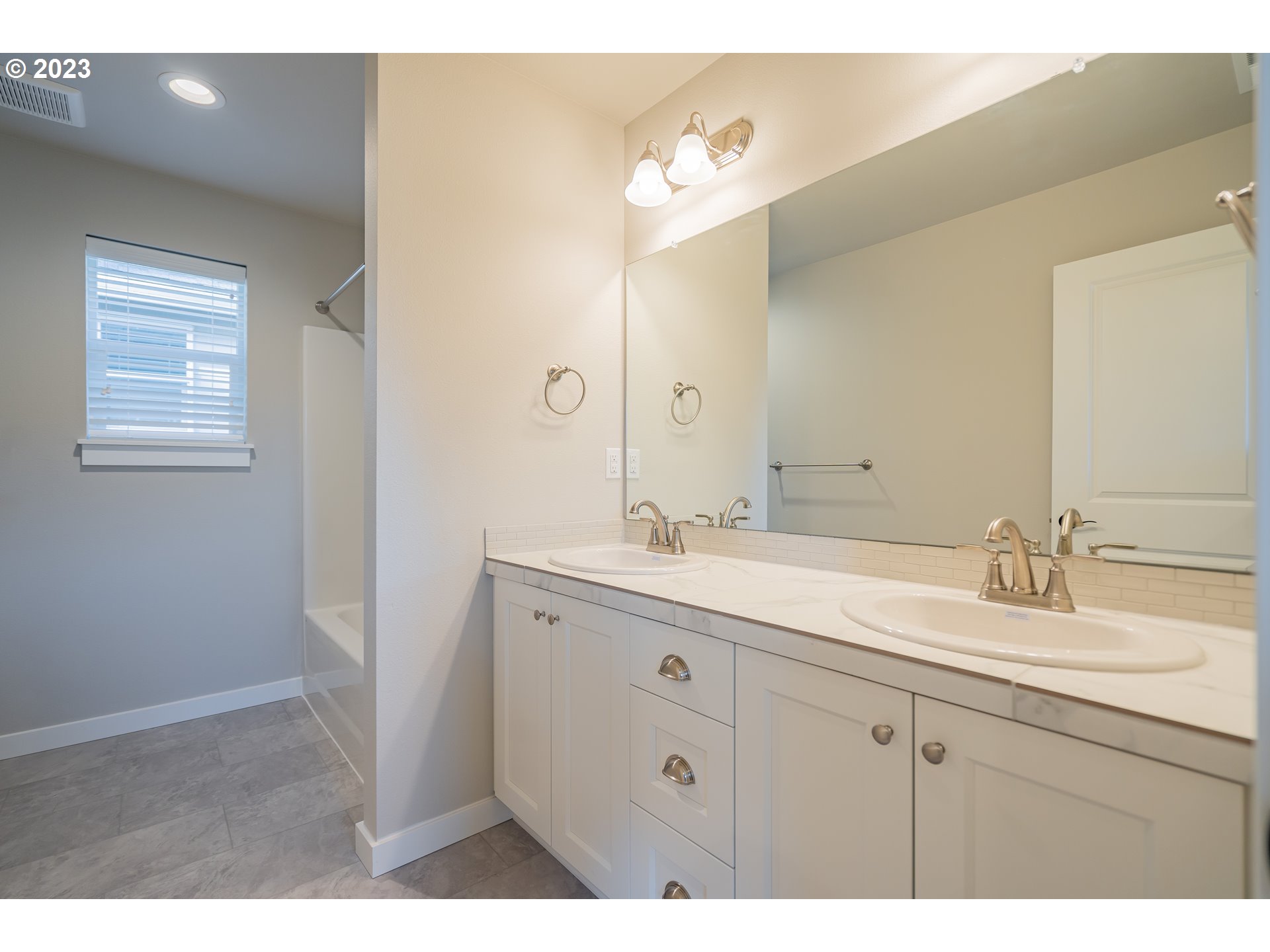 7017 South 13th Street Ridgefield, WA 98642 - Photo 19 of 33 a bathroom with a sink double vanity granite and a mirror