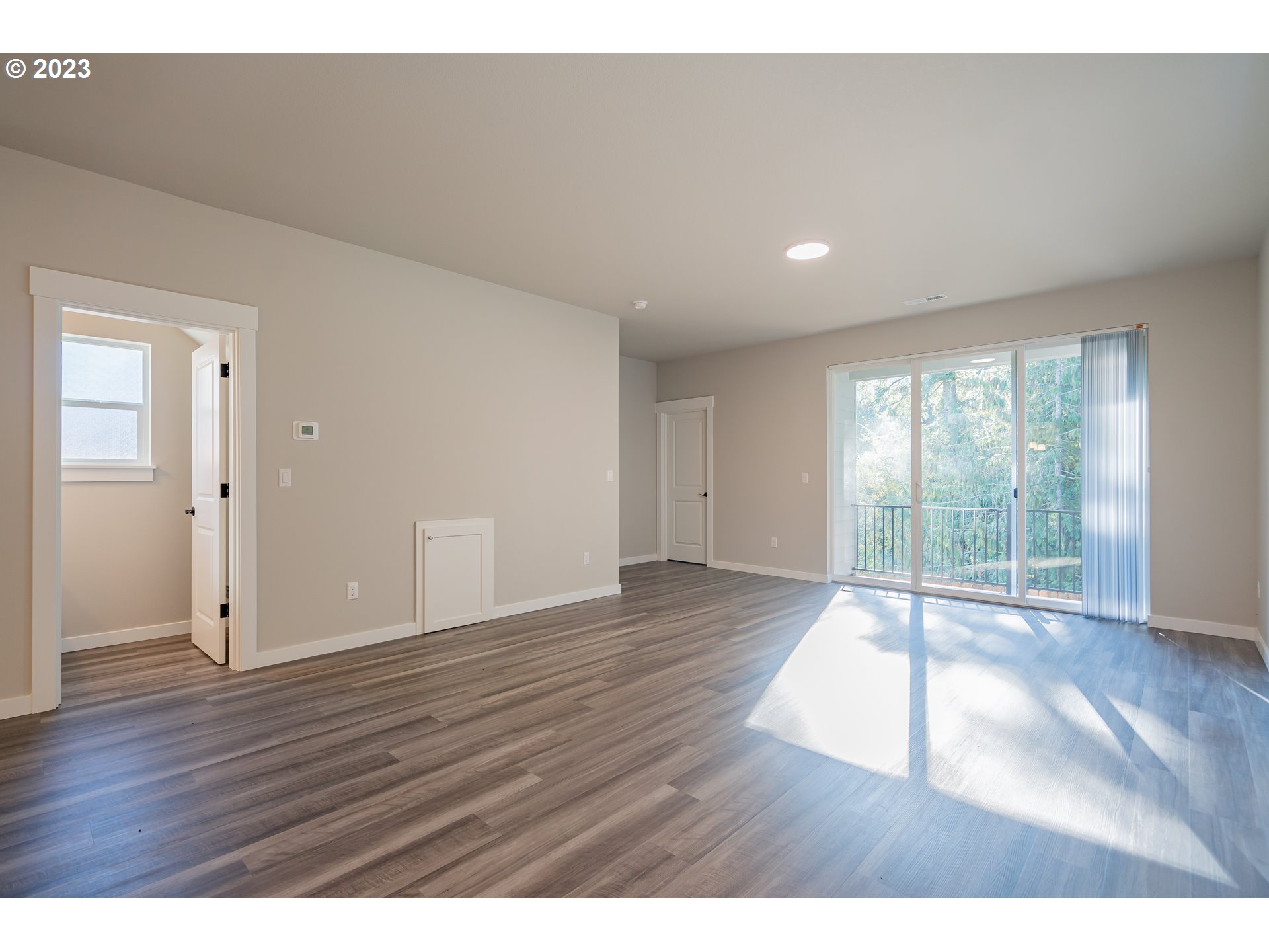 7017 South 13th Street Ridgefield, WA 98642 - Photo 9 of 33 a view of an empty room with wooden floor and a window