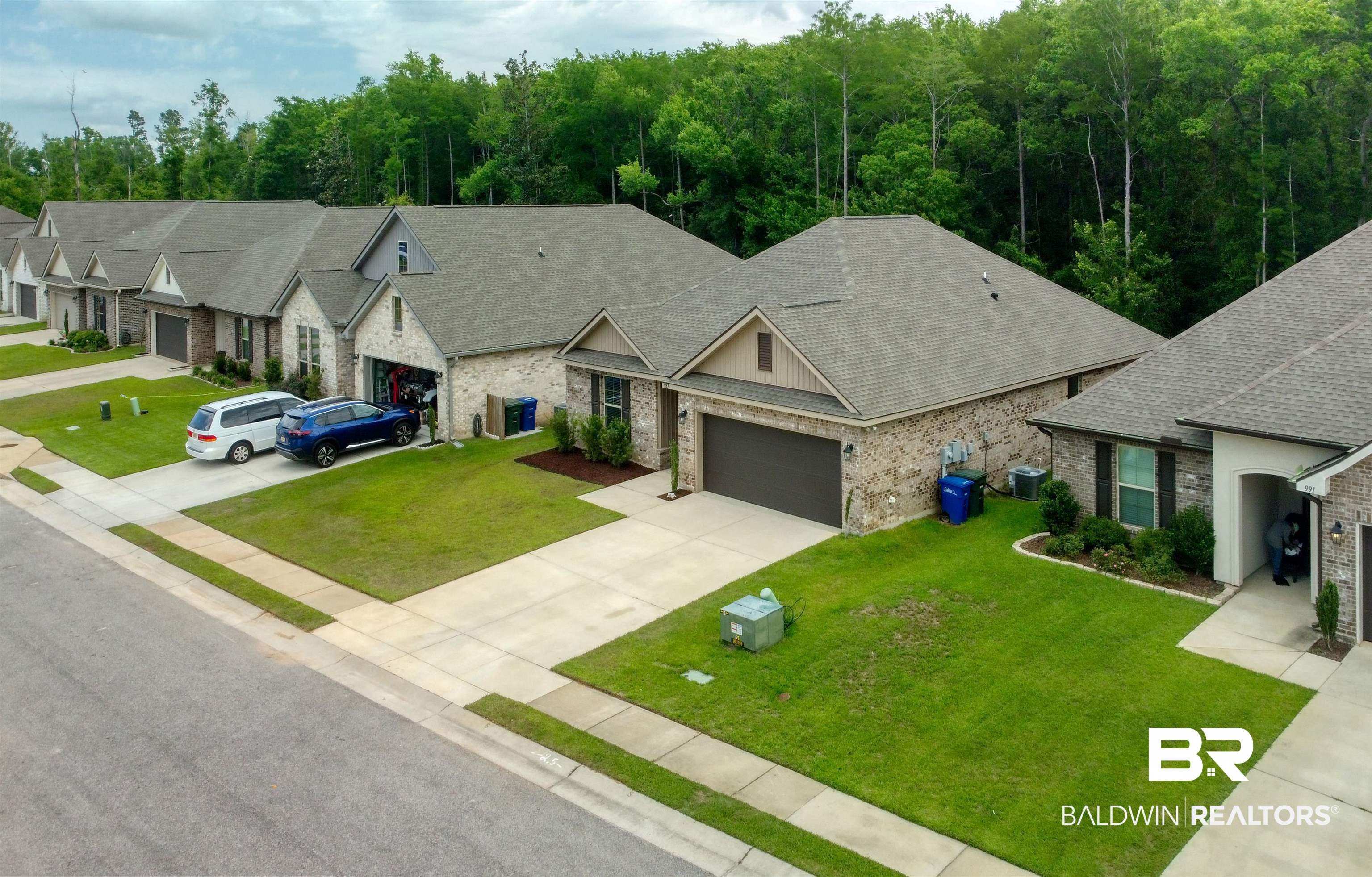 987 Gibson Court Foley, AL 36535 - Photo 4 of 34 Ranch-style home featuring roof with shingles, a front lawn, concrete driveway, an attached garage, and stone siding