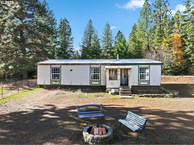 a view of a house with backyard and sitting area