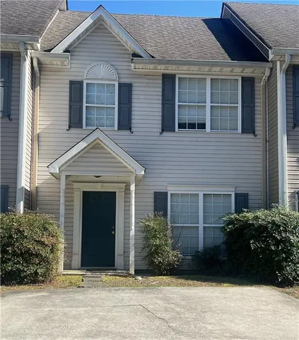 a front view of a house with a garden