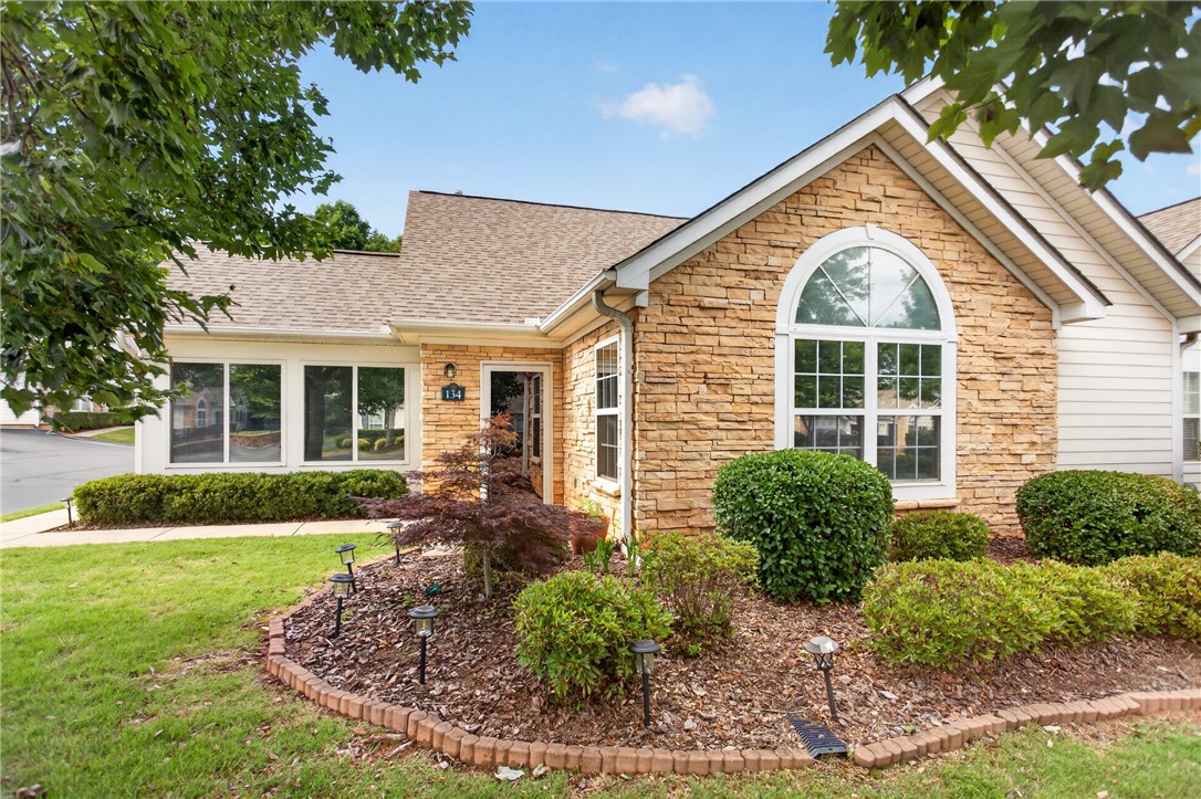 134 Life Style Lane Anderson, SC 29621 - Photo 1 of 44 Front facade showcases charming stone veneer, a gracefully arched window, and meticulously maintained landscaping.