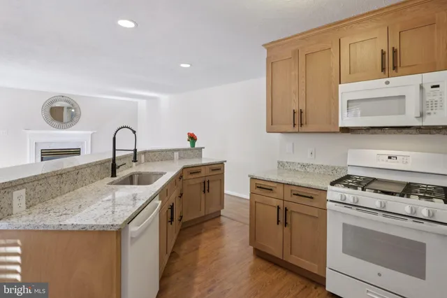 a view of center kitchen island a sink a refrigerator and a window