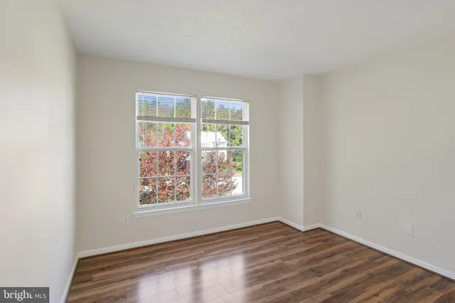 a view of a hallway with wooden floor and closet