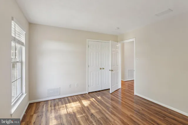 a view of empty room with wooden floor