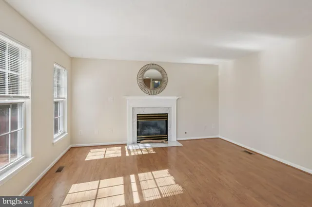 a view of an empty room with a fireplace and a window