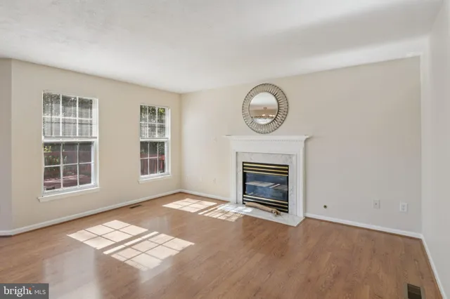 a view of empty room with wooden floor and windows
