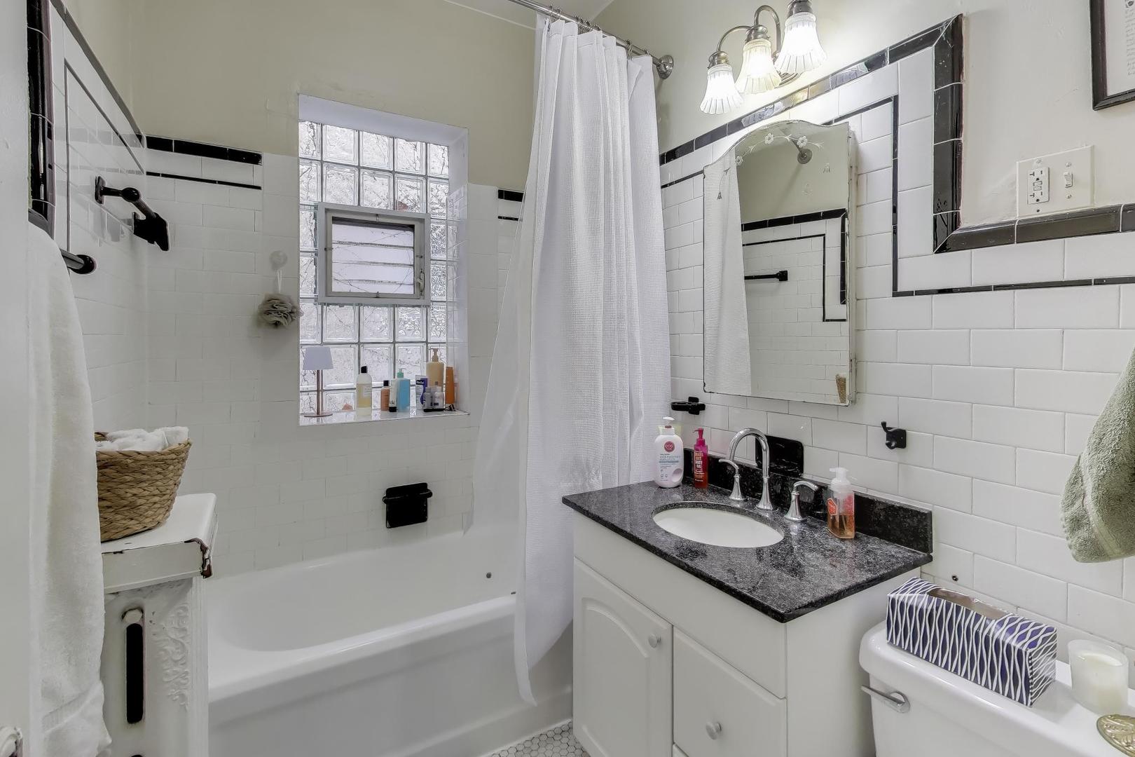 2245 West Giddings Street Chicago, IL 60625 - Photo 29 of 50 a bathroom with a granite countertop sink a toilet and shower