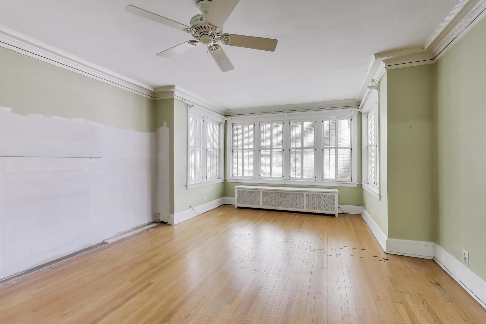 2245 West Giddings Street Chicago, IL 60625 - Photo 4 of 50 an empty room with wooden floor fan and windows