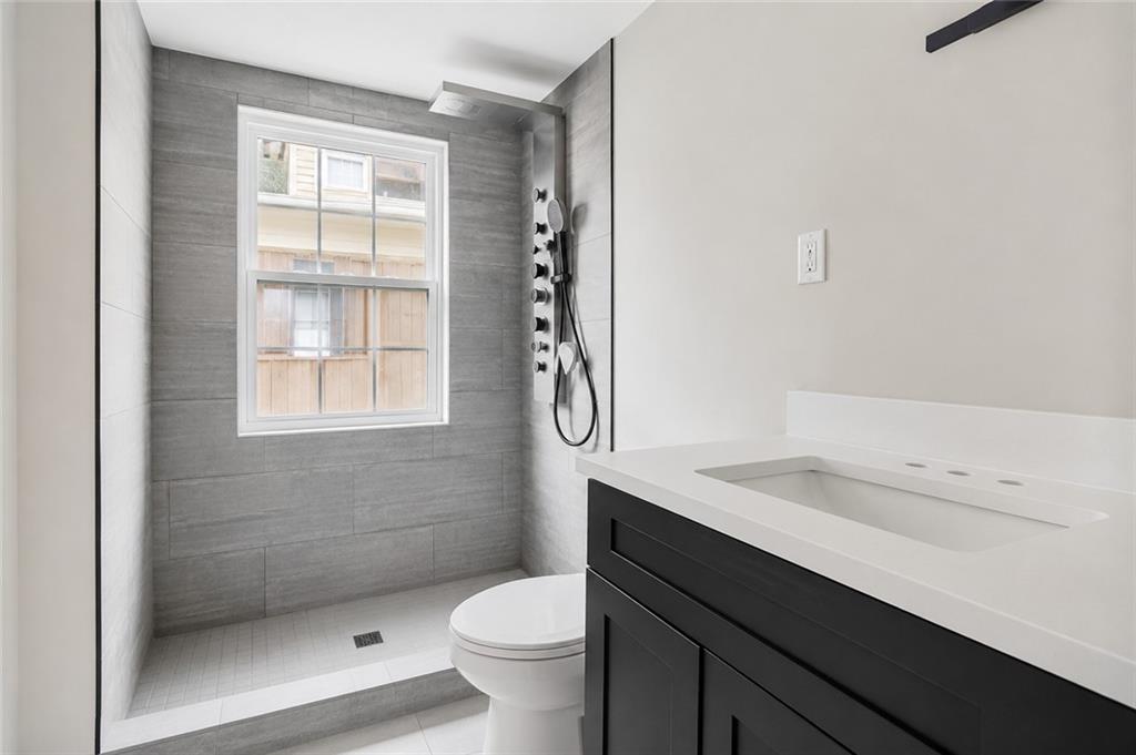 665 Lexington Avenue Southwest Atlanta, GA 30310 - Photo 11 of 33 a bathroom with a granite countertop sink a toilet and shower