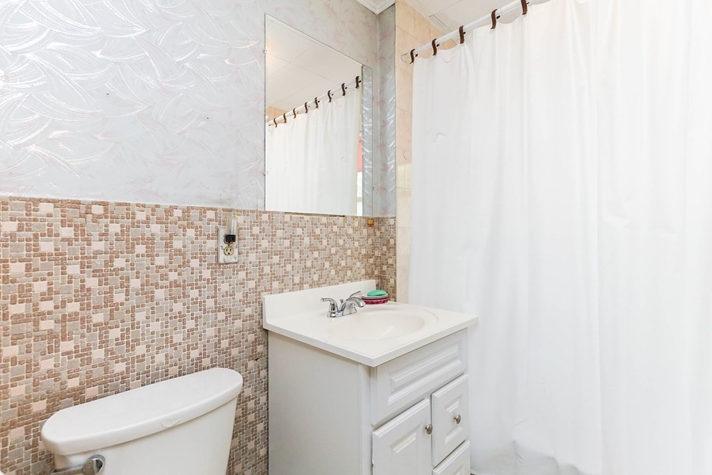 45 Redlands Road Boston, MA 02132 - Photo 13 of 41 a bathroom with a sink a toilet and a mirror