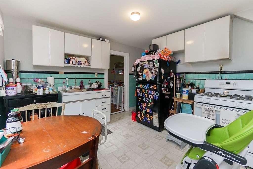 45 Redlands Road Boston, MA 02132 - Photo 19 of 41 a kitchen filled with stainless steel appliances kitchen island granite countertop a table chairs and a refrigerator