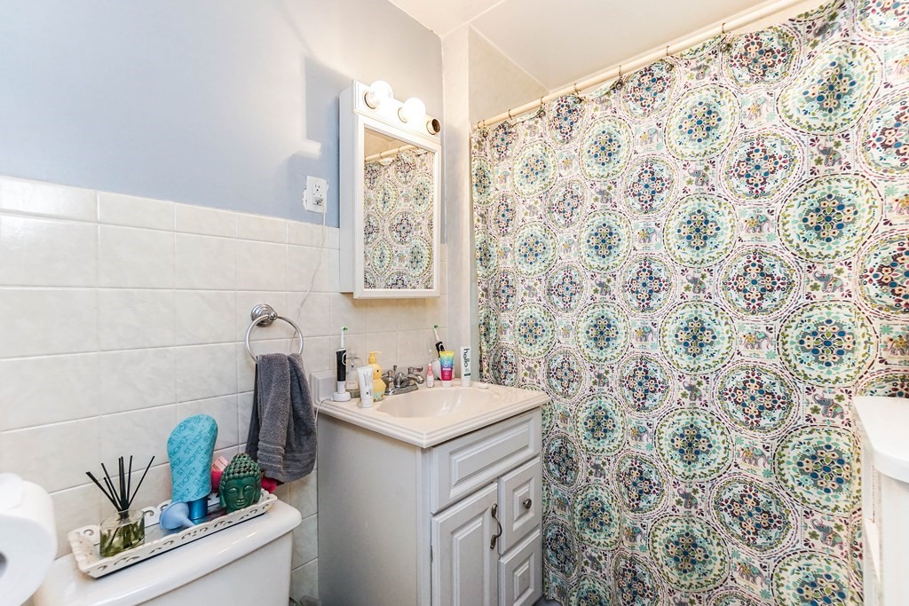 45 Redlands Road Boston, MA 02132 - Photo 28 of 41 a bathroom with a sink a vanity and a shower curtain
