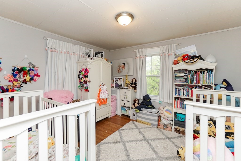 45 Redlands Road Boston, MA 02132 - Photo 30 of 41 a storage room with furniture a baby crib and a book shelf