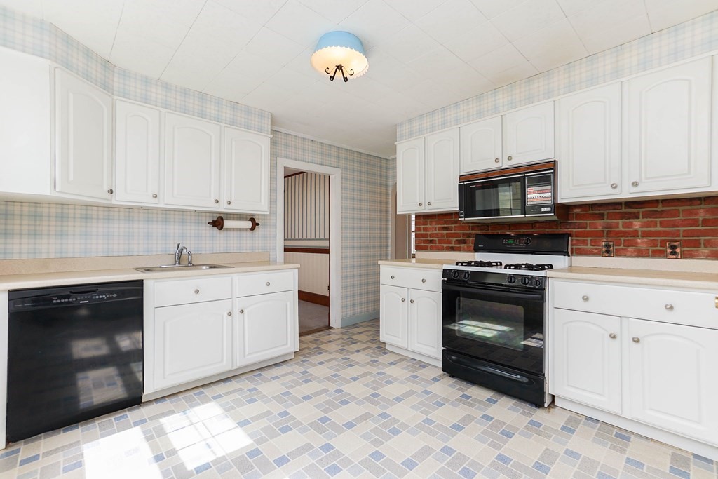 45 Redlands Road Boston, MA 02132 - Photo 5 of 41 a kitchen with granite countertop a stove top oven microwave and cabinets