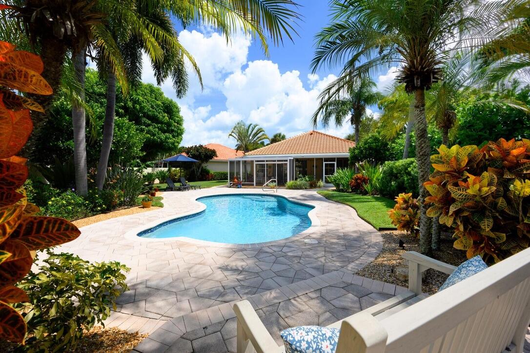 174 Hampton Circle Jupiter, FL 33458 - Photo 1 of 45 a view of a swimming pool with lawn chairs under an umbrella
