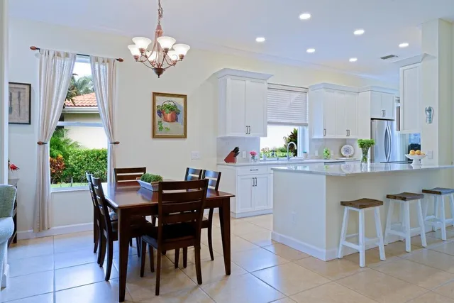 a dining room filled chandelier and kitchen view