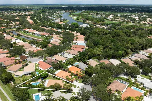 a view of a white building with a yard
