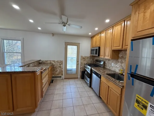 a large kitchen with cabinets wooden floor and stainless steel appliances