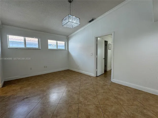 a view of a livingroom with a chandelier fan and windows